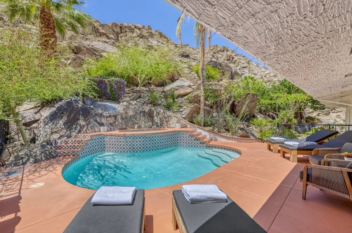 The pool terrace set against the boulders and desert planting of The Mesa hillside.